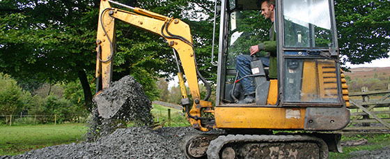 Person som kör minigrävare