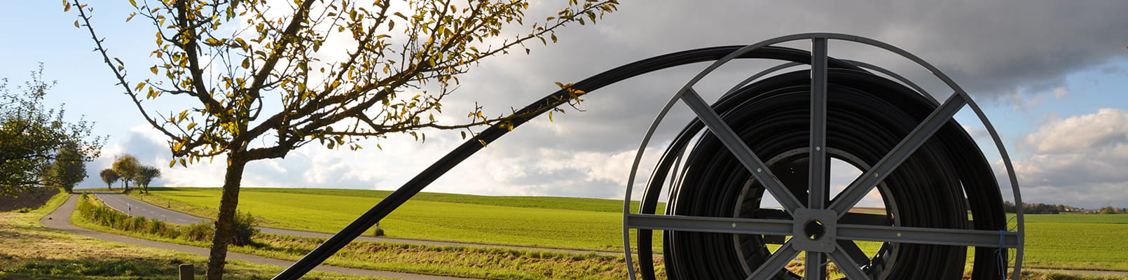 Kabelrulle med svart kabel står bredvid landsväg