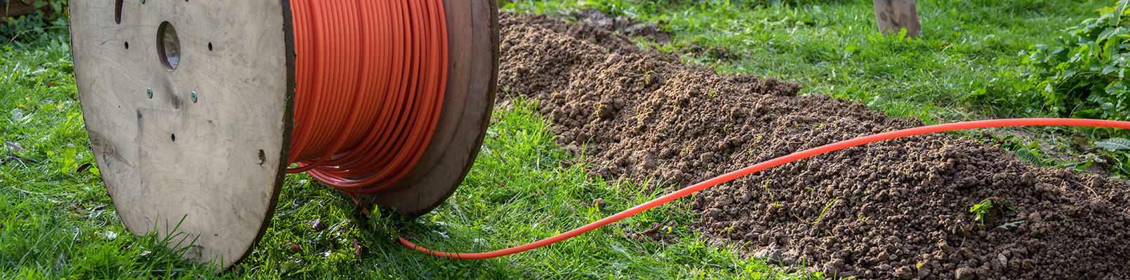 Kabelrulle med slang för fiber på gräsmatta